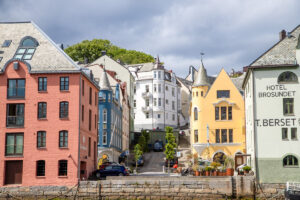 Kleurrijke vispakhuizen langs de haven van Ålesund.